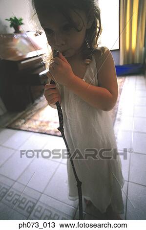 Stock Image - Young girl holding a branch. Fotosearch