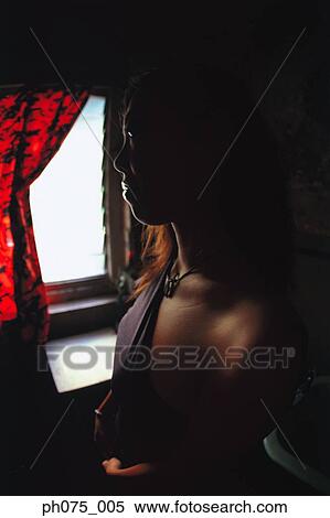 Silhouette of young woman by window View Large Photo Image Stock Photography - Silhouette of young woman by window. Fotosearch