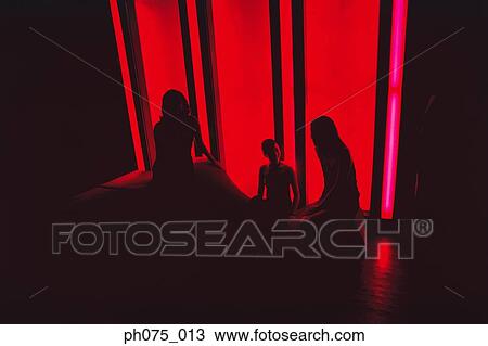 Stock Image - Silhouette of young women in nightclub. Fotosearch