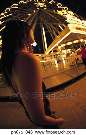 Young woman at amusement park, side view View Large Photo Image Stock Image - Young woman at amusement park, side view. Fotosearch