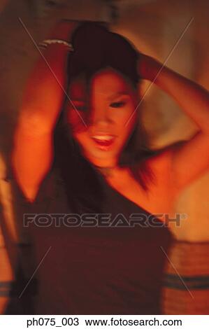 Stock Image - Young woman dancing, high section, portrait . Fotosearch