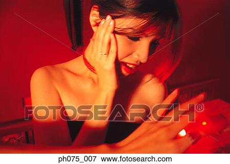 Young woman placing hand to side of face View Large Photo Image Stock Photo - Young woman placing hand to side of face. Fotosearch