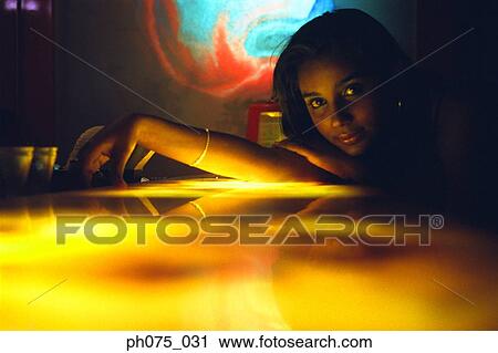 Stock Image - Young woman resting head on bar counter. Fotosearch