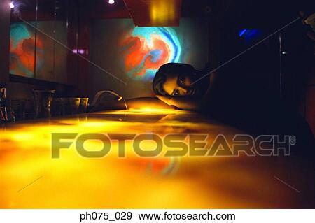 Young woman resting head on bar counter View Large Photo Image Stock Photo - Young woman resting head on bar counter. Fotosearch