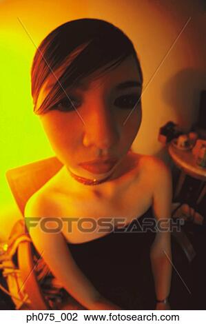 Stock Image - Young woman sitting in nightclub. Fotosearch