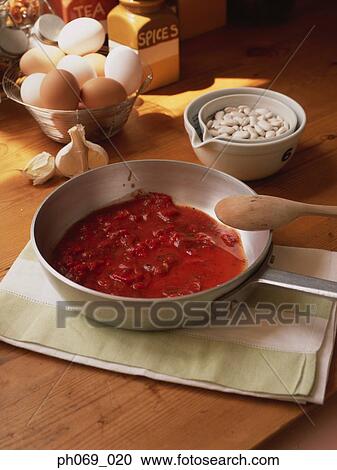 Pan of tomato sauce and ingredients on kitchen table View Large Photo Image Stock Image - Pan of tomato sauce and ingredients on kitchen table. Fotosearch