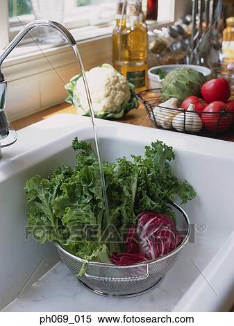 Sieve of vegetables under running water View Large Photo Image Stock Photography - Sieve of vegetables under running water. Fotosearch
