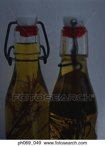 Two bottles of herb infused olive oil View Large Photo Image Stock Photo - Two bottles of herb infused olive oil . Fotosearch