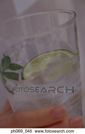 Stock Photography - Woman holding a glass of gin tonic. Fotosearch