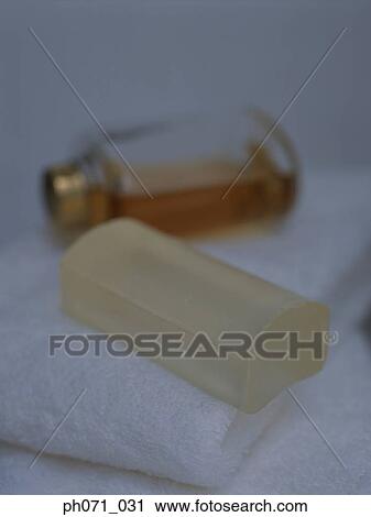 Soap bar and perfume bottle on folded white towels, close-up View Large Photo Image Stock Image - Soap bar and perfume bottle on folded white towels, close-up . Fotosearch