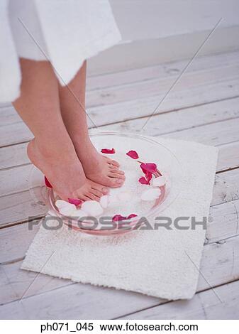 Woman dipping feet in bowl with flower petals View Large Photo Image Stock Photography - Woman dipping feet in bowl with flower petals . Fotosearch