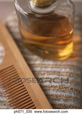 Stock Photography - Wooden comb and perfume bottle, close up. Fotosearch