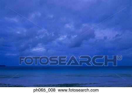 Stock Photo - Clouds over sea at dawn. Fotosearch