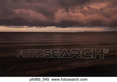 Stock Photography - Cloudy sky and sea at sunset . Fotosearch