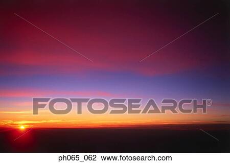 Sunset at sea, dark clouds in orange streaked sky  View Large Photo Image Stock Image - Sunset at sea, dark clouds in orange streaked sky . Fotosearch