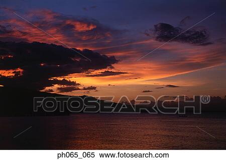 Sunset at sea, dark clouds in orange streaked sky View Large Photo Image Stock Photography - Sunset at sea, dark clouds in orange streaked sky . Fotosearch