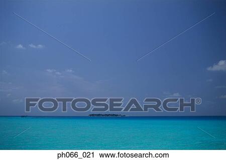 Stock Image - Calm ocean, island in distance. Fotosearch
