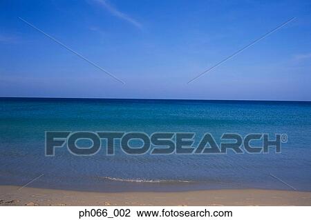 Clear blue sea washing against sandy beach View Large Photo Image Stock Image - Clear blue sea washing against sandy beach . Fotosearch