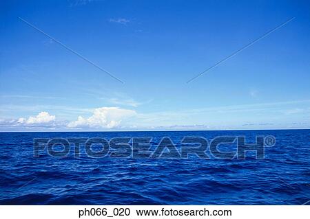 Stock Image - Surface of blue sea to clouds on horizon . Fotosearch