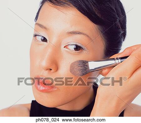 Picture - Young woman applying brusher. Fotosearch
