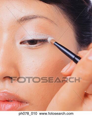Young woman applying eye shadow View Large Photo Image Stock Image - Young woman applying eye shadow. Fotosearch
