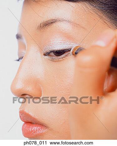 Young woman applying eye shadow View Large Photo Image Stock Image - Young woman applying eye shadow. Fotosearch