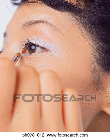 Young woman applying eye shadow View Large Photo Image Stock Image - Young woman applying eye shadow. Fotosearch