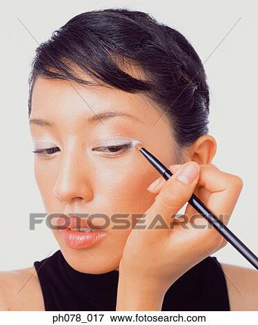 Young woman applying eye shadow View Large Photo Image Stock Photo - Young woman applying eye shadow. Fotosearch