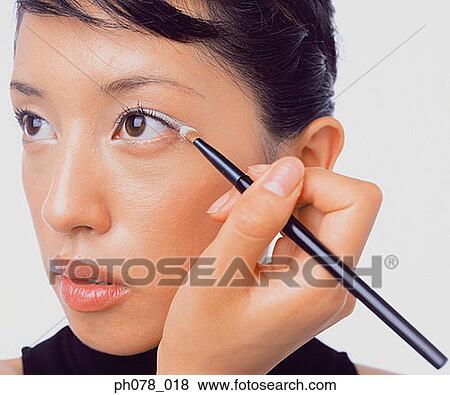 Young woman applying eye shadow View Large Photo Image Stock Photo - Young woman applying eye shadow. Fotosearch