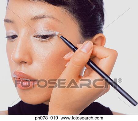 Young woman applying eye shadow View Large Photo Image Stock Photo - Young woman applying eye shadow. Fotosearch