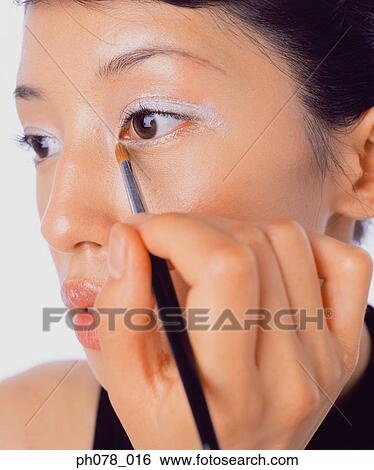 Young woman applying eye shadow View Large Photo Image Stock Photograph - Young woman applying eye shadow. Fotosearch