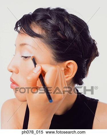 Young woman applying eye shadow View Large Photo Image Stock Photography - Young woman applying eye shadow. Fotosearch