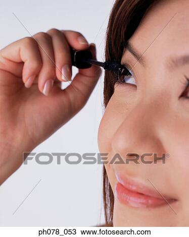 Young woman applying mascara View Large Photo Image Stock Image - Young woman applying mascara. Fotosearch