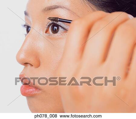 Stock Photo - Young woman applying mascara. Fotosearch