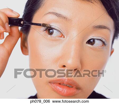 Stock Photograph - Young woman applying mascara. Fotosearch