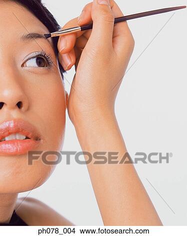 Young woman using eyebrow brush View Large Photo Image Picture - Young woman using eyebrow brush. Fotosearch