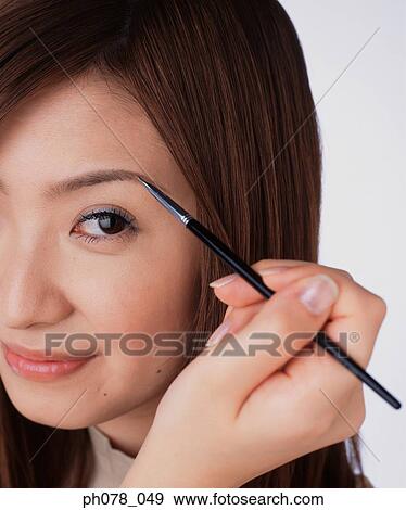 Young woman using eyebrow brush View Large Photo Image Stock Photo - Young woman using eyebrow brush. Fotosearch