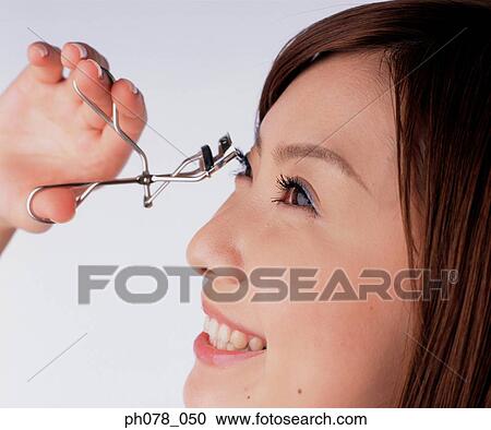 Young woman using eyelash curler View Large Photo Image Stock Image - Young woman using eyelash curler. Fotosearch