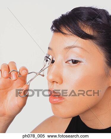 Young woman using eyelash curler View Large Photo Image Stock Photography - Young woman using eyelash curler. Fotosearch