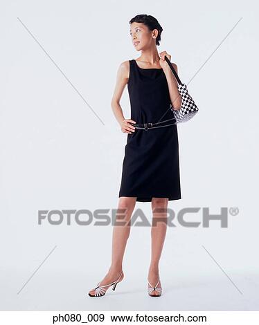 Young woman carrying handbag, hand on hip View Large Photo Image Stock Photo - Young woman carrying handbag, hand on hip . Fotosearch