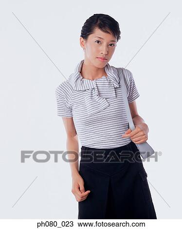 Young woman carrying handbag, posing View Large Photo Image Stock Image - Young woman carrying handbag, posing. Fotosearch