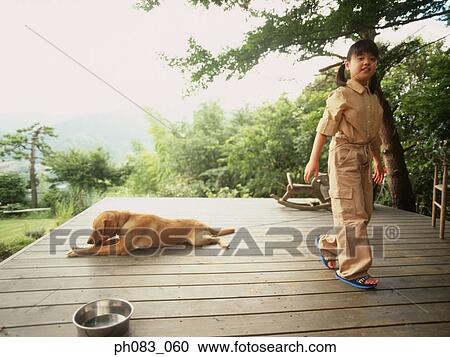 Stock Image - Dog resting, girl walking away. Fotosearch