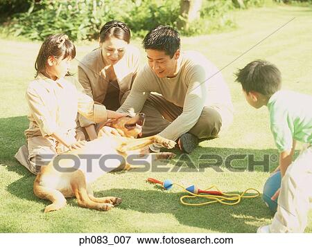 Family sitting in a park with pet dog View Large Photo Image Stock Photo - Family sitting in a park with pet dog. Fotosearch