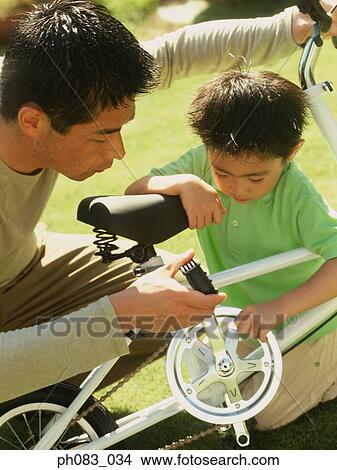 Father and son fixing bicycle View Large Photo Image Picture - Father and son fixing bicycle. Fotosearch
