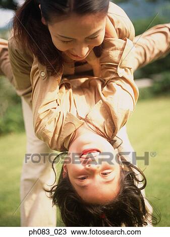 Mother tossing young daughter, close-up View Large Photo Image Stock Image - Mother tossing young daughter, close-up. Fotosearch