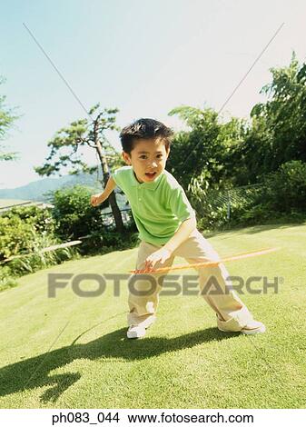 Young boy playing with hula hoop View Large Photo Image Picture - Young boy playing with hula hoop. Fotosearch
