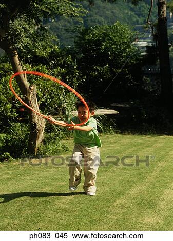 Young boy playing with hula hoop View Large Photo Image Stock Photography - Young boy playing with hula hoop. Fotosearch