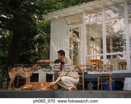 Stock Image - Young couple with pet dogs. Fotosearch
