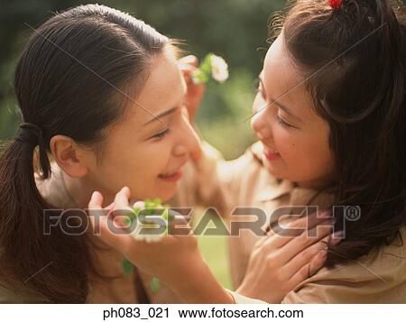 Young daughter giving flower to mother View Large Photo Image Stock Image - Young daughter giving flower to mother. Fotosearch