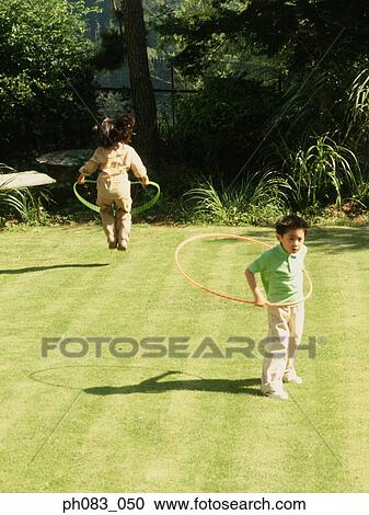 Young girl and boy playing with hula hoop View Large Photo Image Stock Image - Young girl and boy playing with hula hoop. Fotosearch